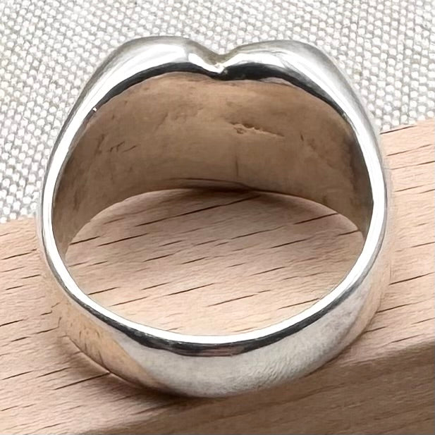 Silver ring on a wooden surface with a textured background