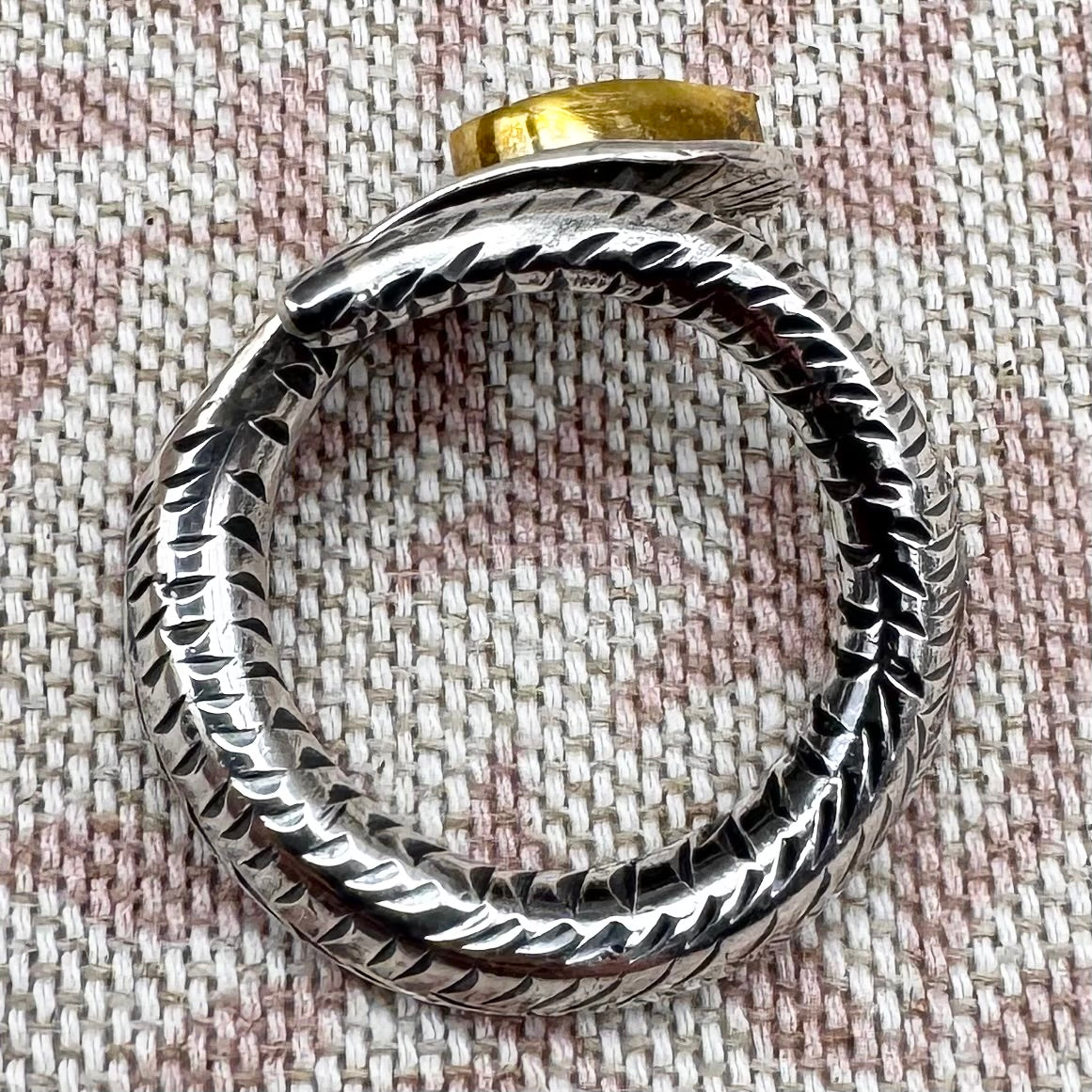 Textured silver ring on fabric background