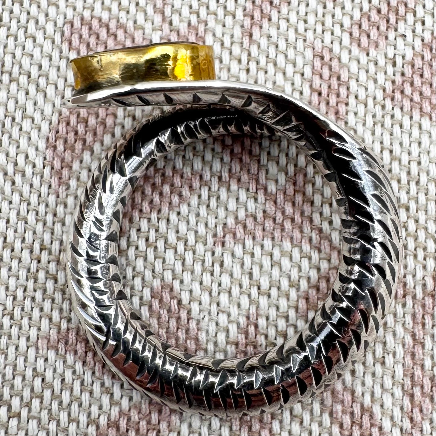 Textured silver ring on fabric background