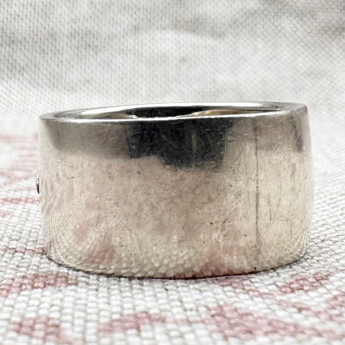 Silver ring on a textured fabric background