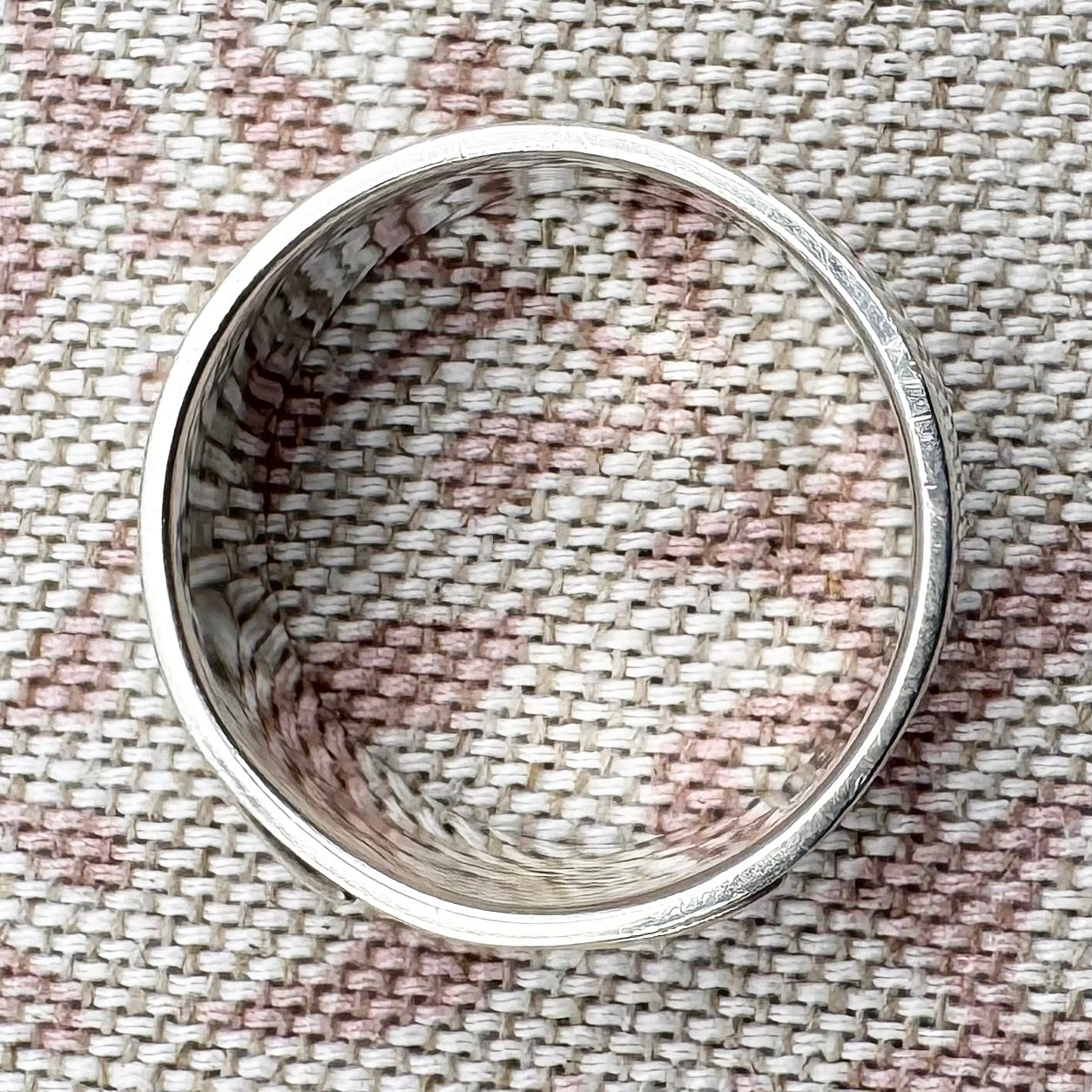 Silver ring on a textured fabric background