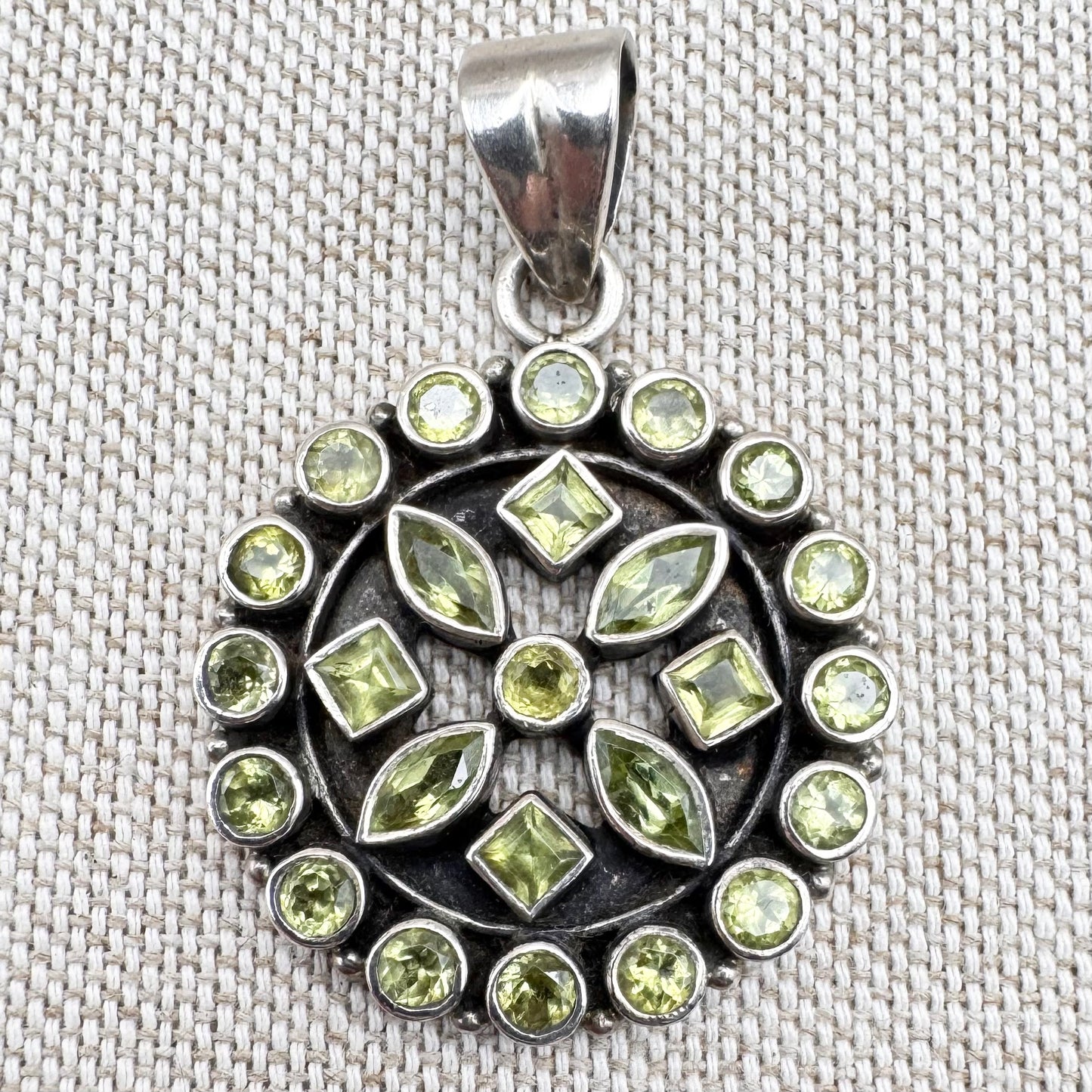 Silver peridot pendant in a circular floral cluster design