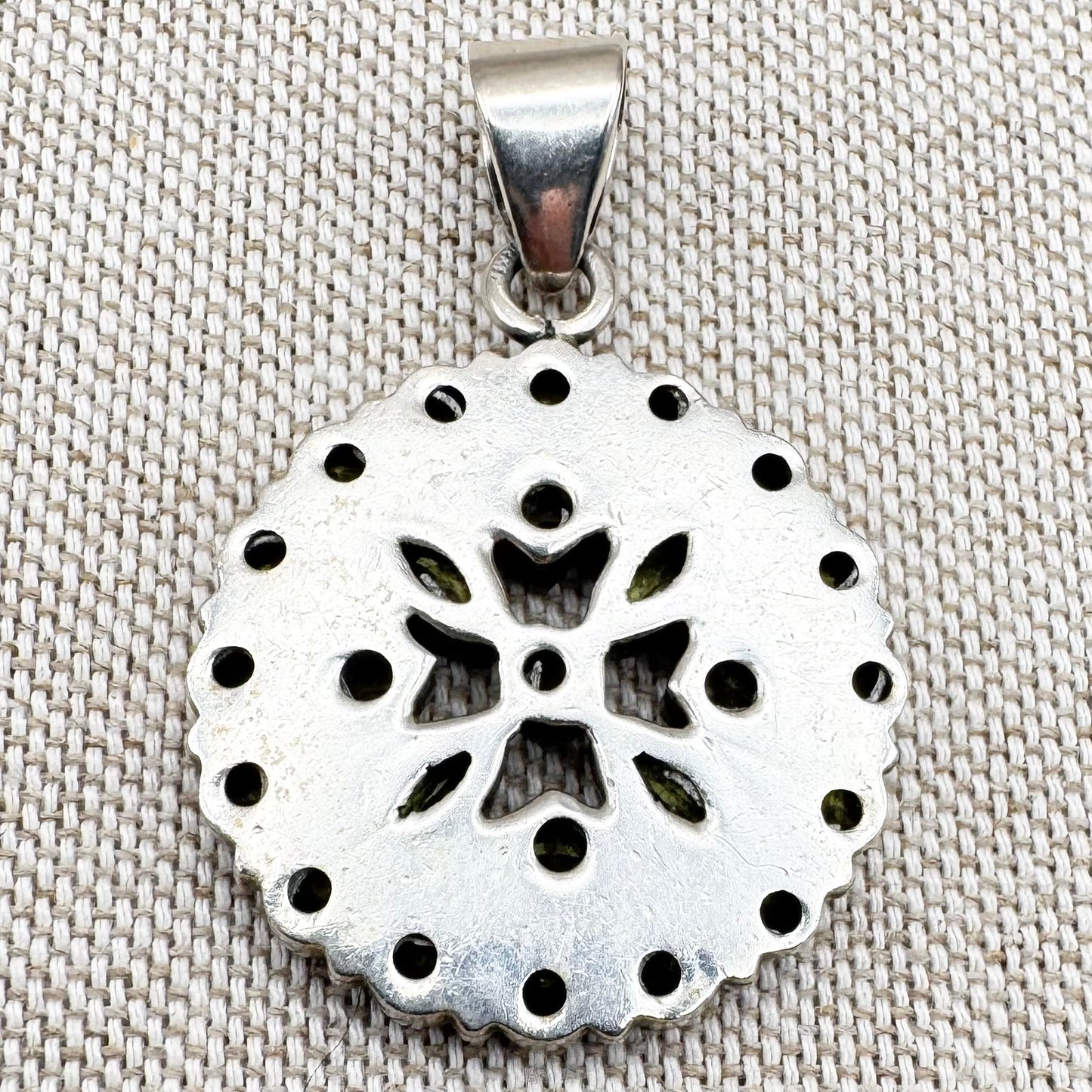 Silver peridot pendant in a circular floral cluster design