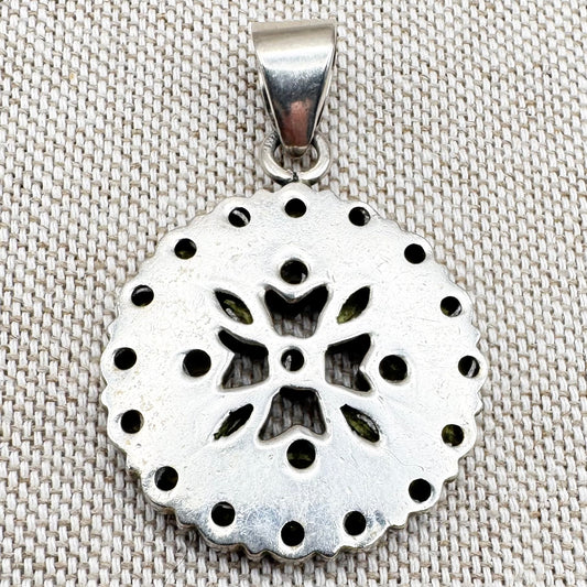 Silver peridot pendant in a circular floral cluster design