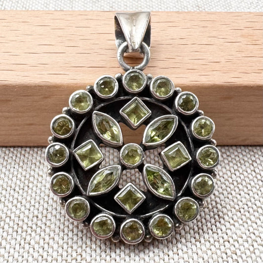 Silver peridot pendant in a circular floral cluster design