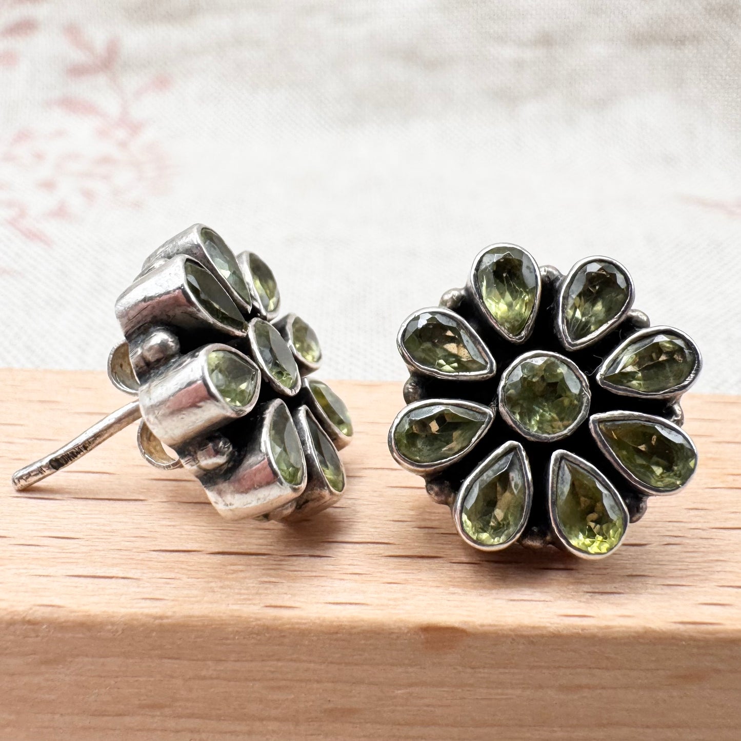 Silver peridot stud earrings in a floral cluster design