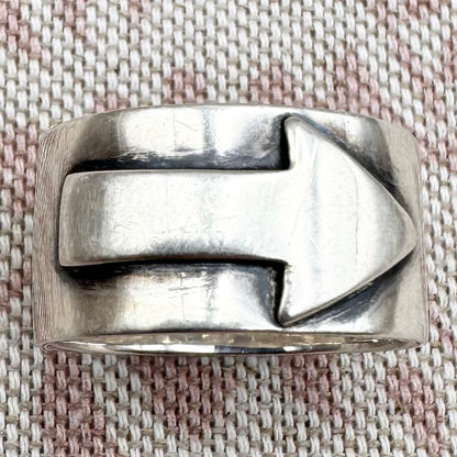 Silver ring with a unique design on a textured fabric background