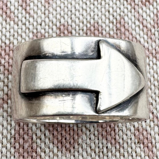 Silver ring with a unique design on a textured fabric background