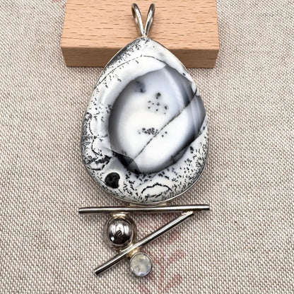 Marble-patterned pendant with a wooden block on a textured beige surface